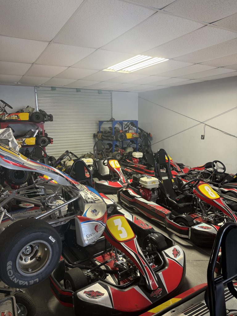 A garage of racing go-karts in bright red and yellow colors. 