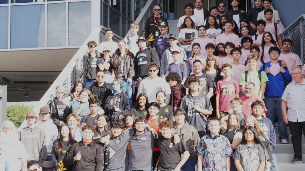 A large group standing on a set of steps outside of a building for Racing the Sun.
